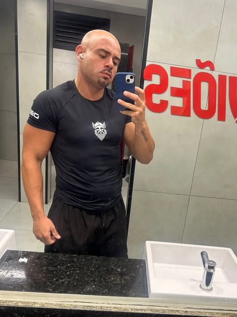 Atleta de camiseta preta NJAL com o brasão do viking em frente ao espelho